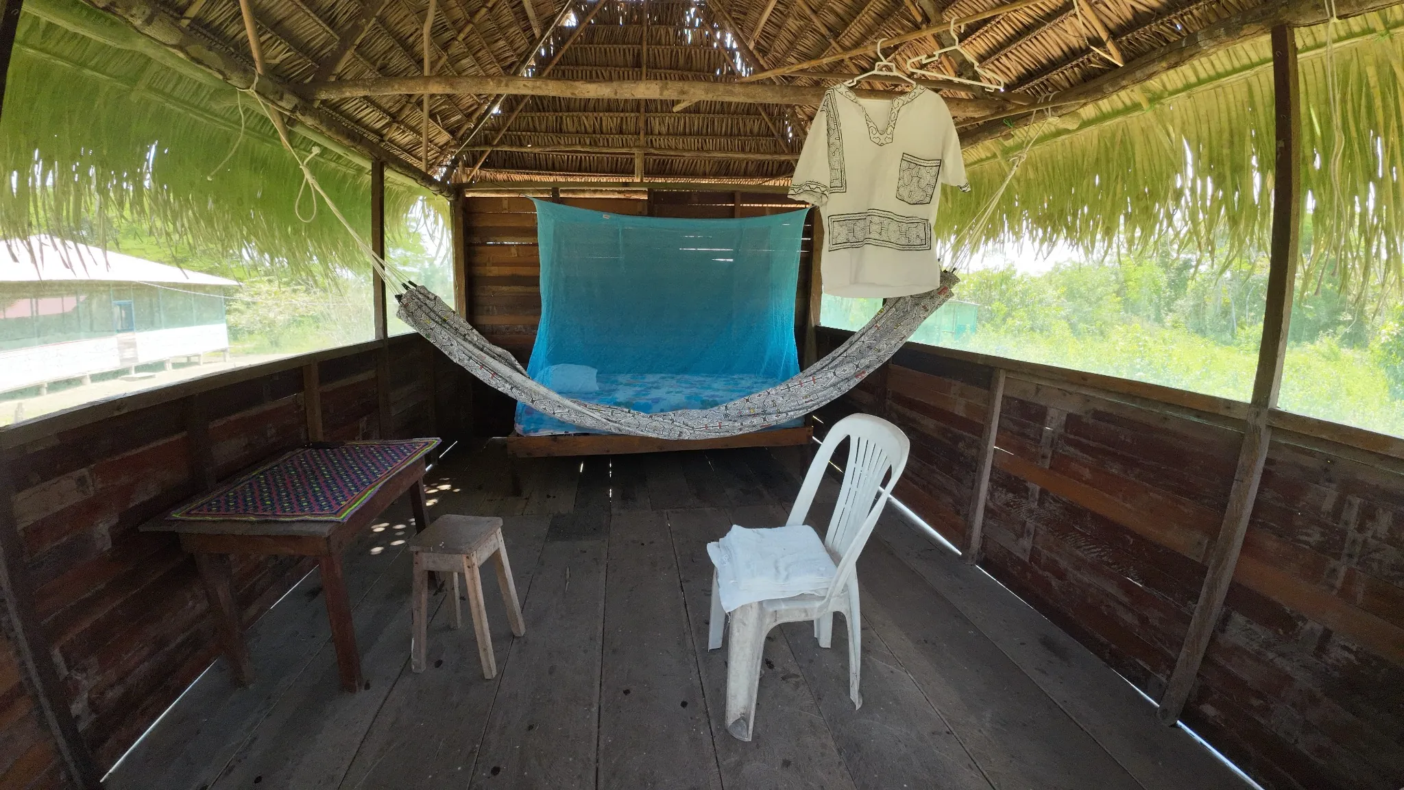 A retreat bedroom with a hammock and blue mosquito net