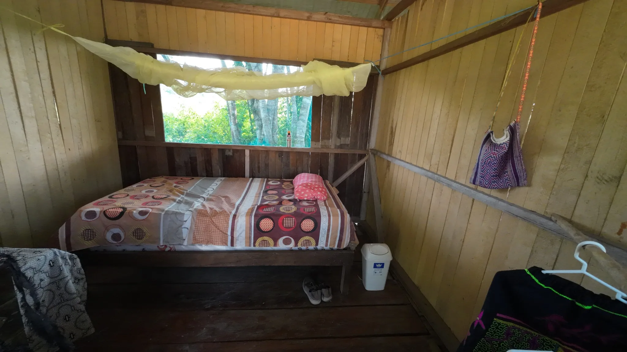 A wooden bedroom with a mosquito net